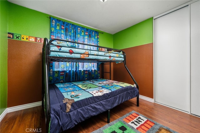 bedroom featuring wood finished floors and baseboards