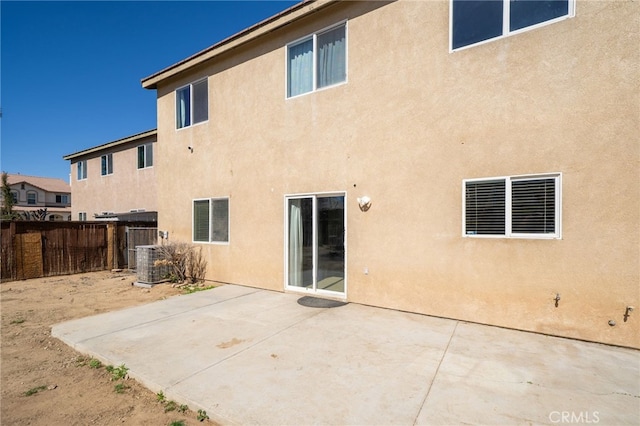 rear view of house featuring a patio, fence, visible vents, and stucco siding