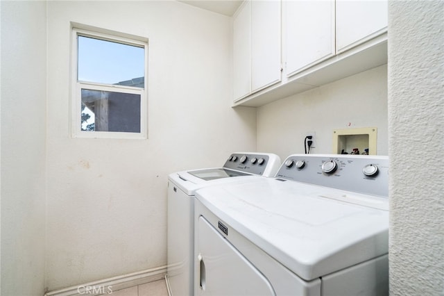 clothes washing area with baseboards, cabinet space, washing machine and clothes dryer, and tile patterned floors