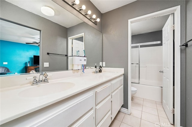 full bath featuring double vanity, toilet, enclosed tub / shower combo, a sink, and tile patterned floors