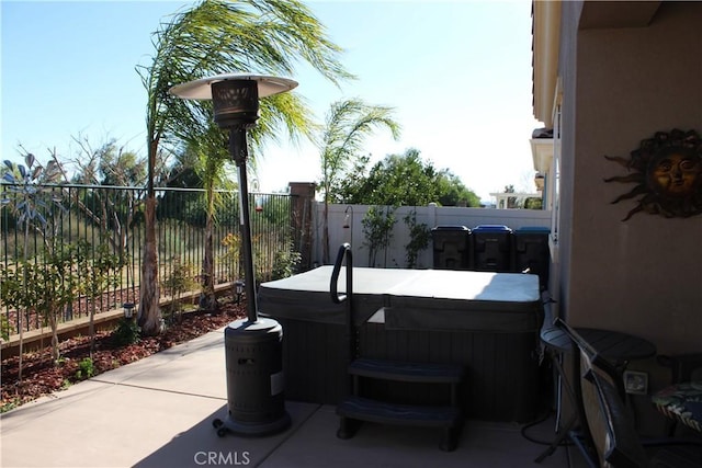 view of patio / terrace featuring a hot tub and a fenced backyard