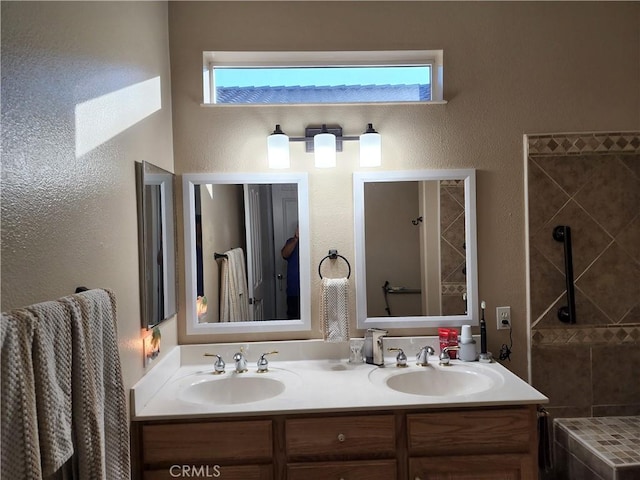 full bathroom with double vanity, plenty of natural light, and a sink