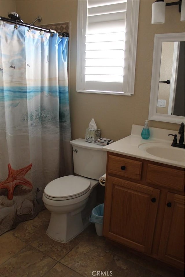 bathroom featuring curtained shower, vanity, toilet, and tile patterned floors