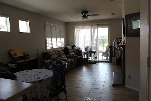 living room with a wealth of natural light, visible vents, ceiling fan, and light tile patterned floors