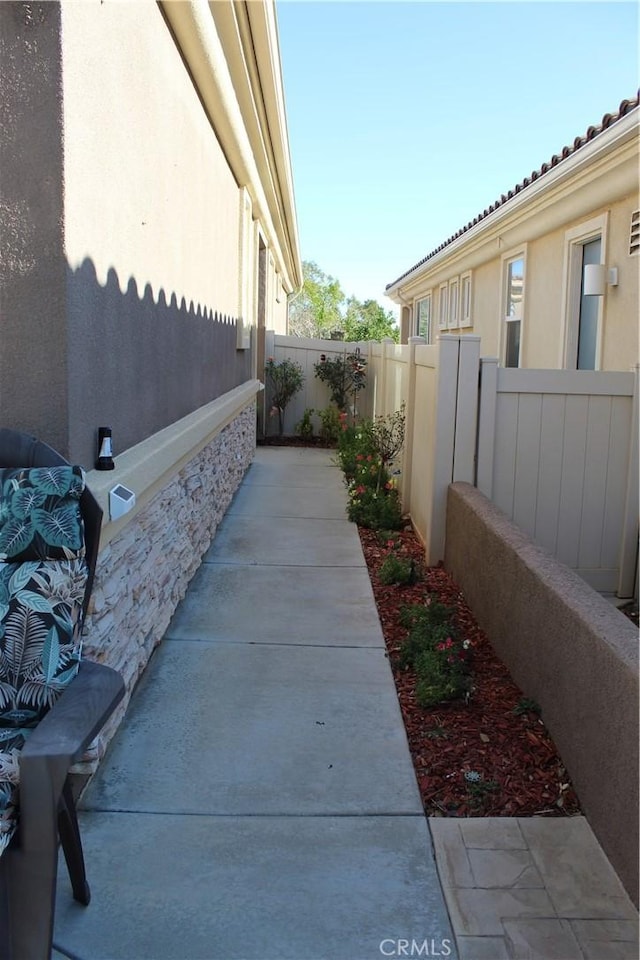 view of side of property with fence and stucco siding