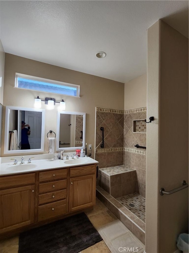 bathroom with double vanity, a healthy amount of sunlight, a walk in shower, and a sink