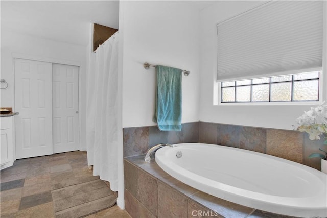 full bath featuring vanity and a garden tub