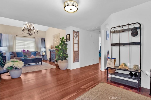 living room featuring a notable chandelier, wood finished floors, and arched walkways
