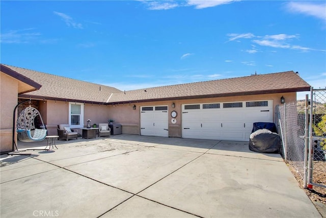 view of front of house with stucco siding, concrete driveway, an attached garage, and fence