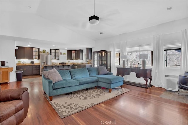 living area with recessed lighting, high vaulted ceiling, visible vents, a ceiling fan, and wood finished floors