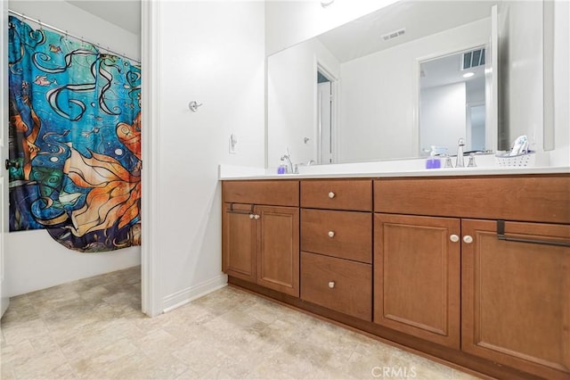 full bath with double vanity, curtained shower, visible vents, and a sink