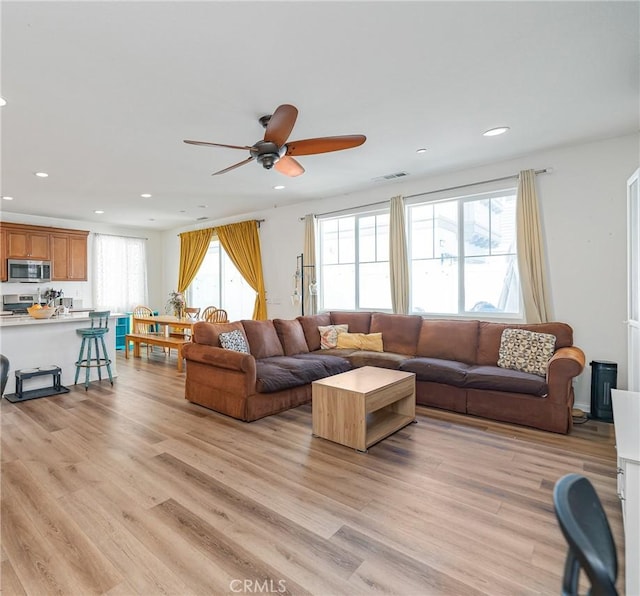 living area featuring light wood-style floors, recessed lighting, visible vents, and ceiling fan