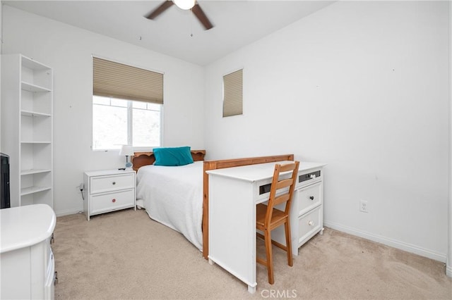 bedroom featuring light carpet, a ceiling fan, and baseboards