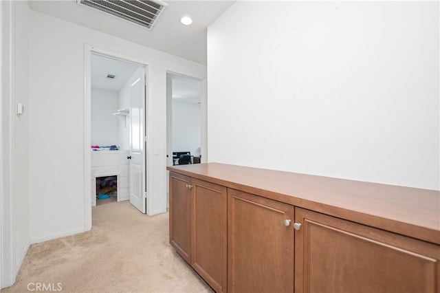 hallway featuring visible vents and light carpet