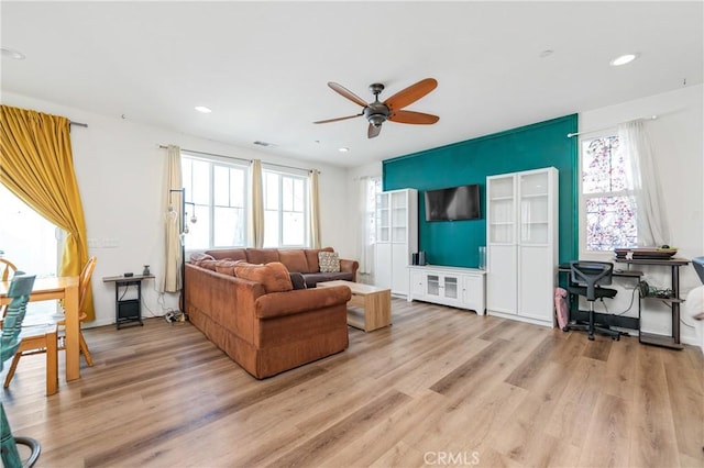 living room with light wood-type flooring, ceiling fan, visible vents, and recessed lighting