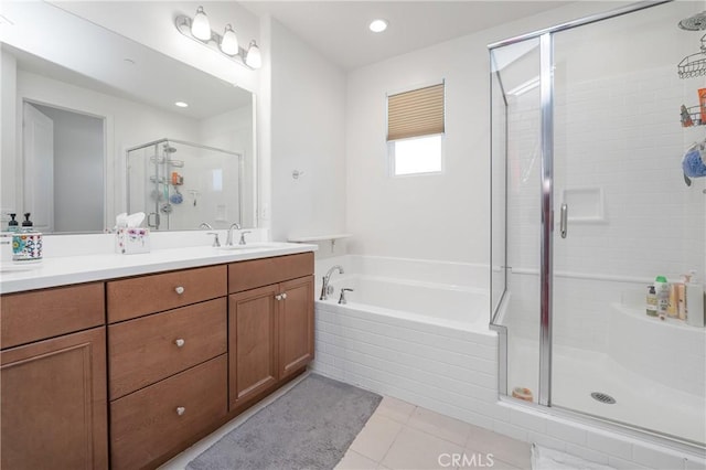 bathroom with double vanity, a stall shower, tile patterned floors, a sink, and a bath