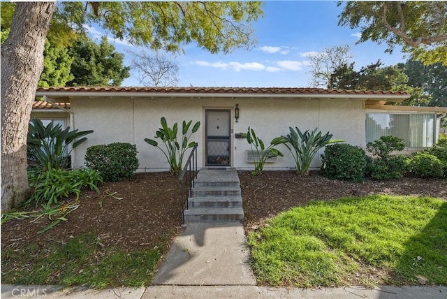 view of front of home with a tile roof and stucco siding