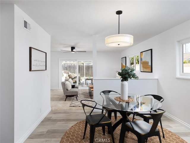 dining space featuring ceiling fan, baseboards, visible vents, and light wood-style flooring