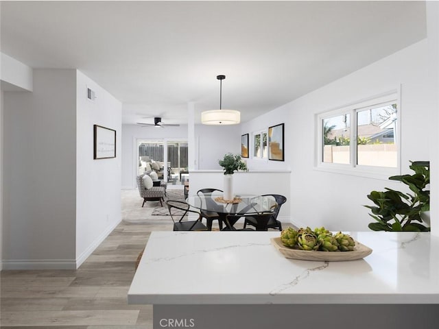 dining room featuring light wood finished floors, baseboards, and visible vents