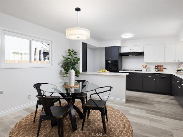 dining space with light wood-type flooring and baseboards