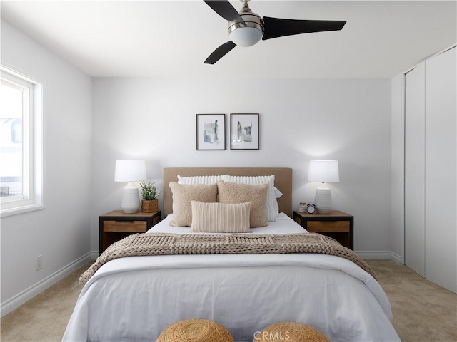 bedroom featuring baseboards, a ceiling fan, and light colored carpet