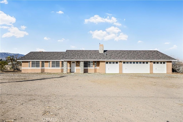 single story home featuring dirt driveway, a chimney, a garage, and stucco siding