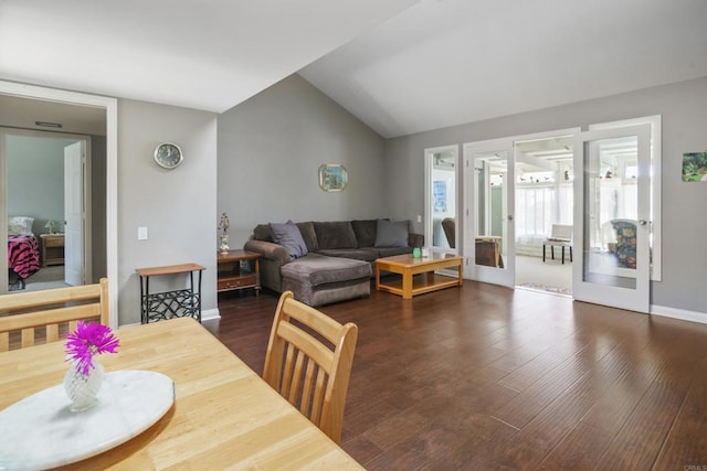 dining room featuring dark wood-style floors, french doors, vaulted ceiling, and baseboards