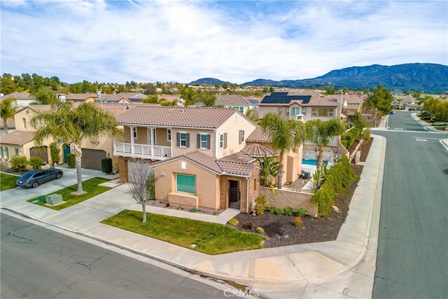 view of front of house featuring a mountain view, concrete driveway, a tile roof, and a residential view