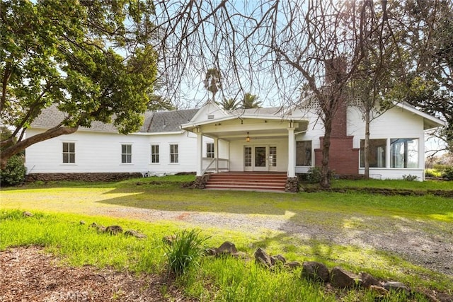 back of house with a yard and a porch