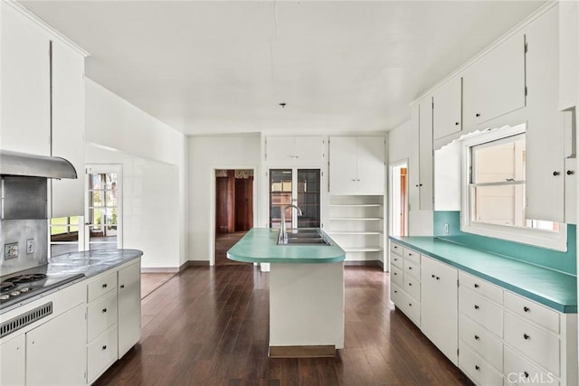 kitchen featuring stainless steel gas cooktop, white cabinetry, dark wood-type flooring, and a sink