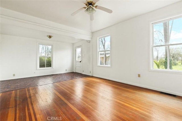 spare room featuring a wealth of natural light, visible vents, and hardwood / wood-style flooring