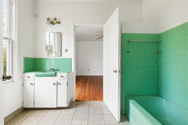 full bathroom featuring tasteful backsplash, baseboards, tile patterned flooring, vanity, and washtub / shower combination