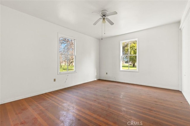 spare room featuring baseboards, ceiling fan, and hardwood / wood-style floors