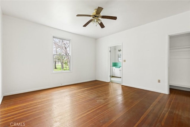 unfurnished bedroom with baseboards, a ceiling fan, wood-type flooring, a walk in closet, and a closet