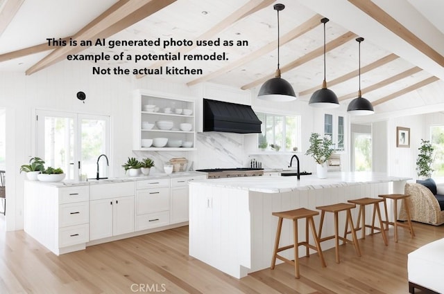 kitchen featuring lofted ceiling with beams, light stone countertops, premium range hood, and a sink