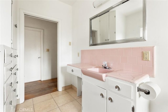 bathroom featuring a sink, tile patterned flooring, and backsplash