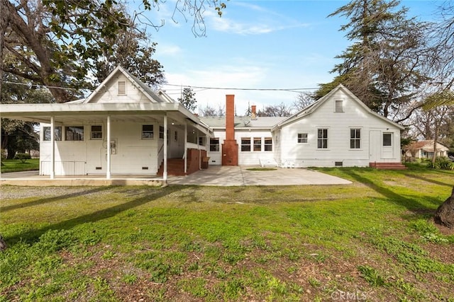 back of house featuring entry steps, crawl space, a patio area, and a lawn