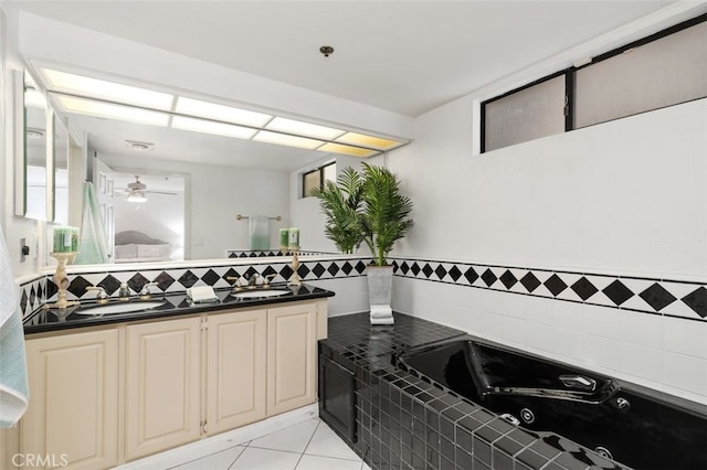 kitchen featuring light tile patterned floors, tasteful backsplash, dark countertops, ceiling fan, and a sink