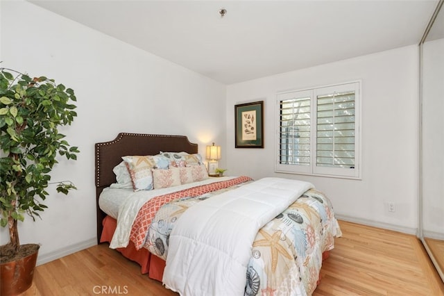 bedroom featuring wood finished floors and baseboards