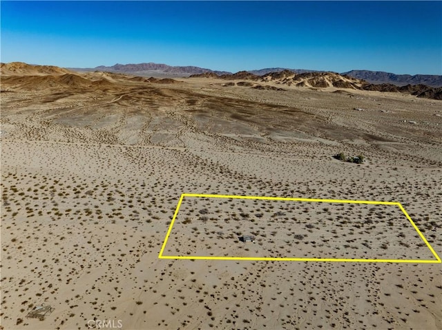 drone / aerial view featuring view of desert and a mountain view