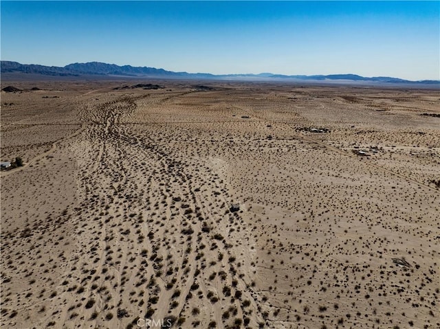 drone / aerial view featuring a mountain view and view of desert