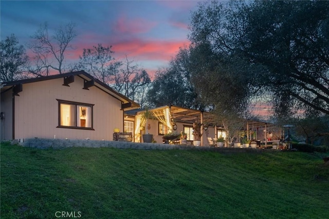 back of house at dusk with a yard