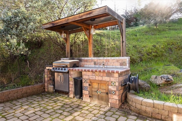 view of patio with a sink, a grill, and exterior kitchen