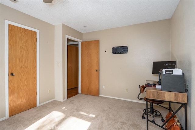 carpeted office featuring visible vents, a textured ceiling, and baseboards