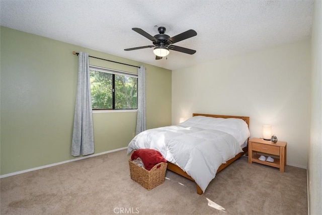 bedroom featuring carpet floors, a ceiling fan, baseboards, and a textured ceiling