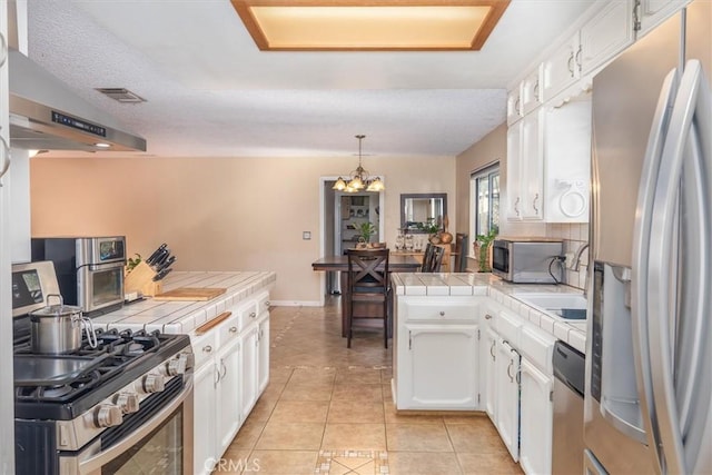 kitchen featuring light tile patterned floors, visible vents, white cabinets, tile countertops, and appliances with stainless steel finishes