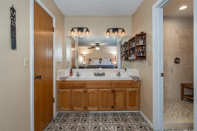 bathroom featuring double vanity, a tile shower, a textured ceiling, ensuite bath, and ceiling fan