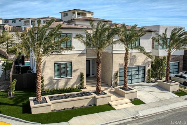 view of front of home featuring driveway, a garage, and stucco siding