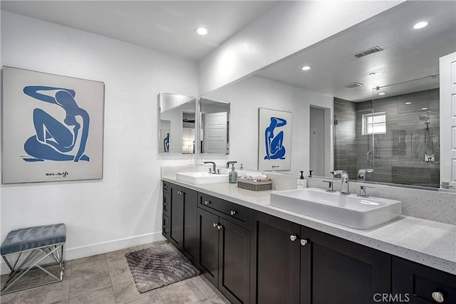 bathroom with double vanity, a sink, visible vents, and a shower stall