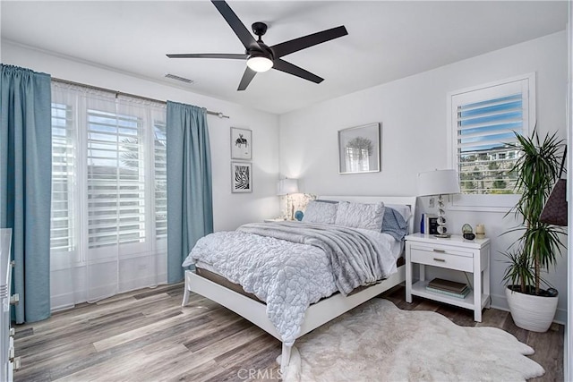 bedroom featuring light wood-type flooring, visible vents, and a ceiling fan